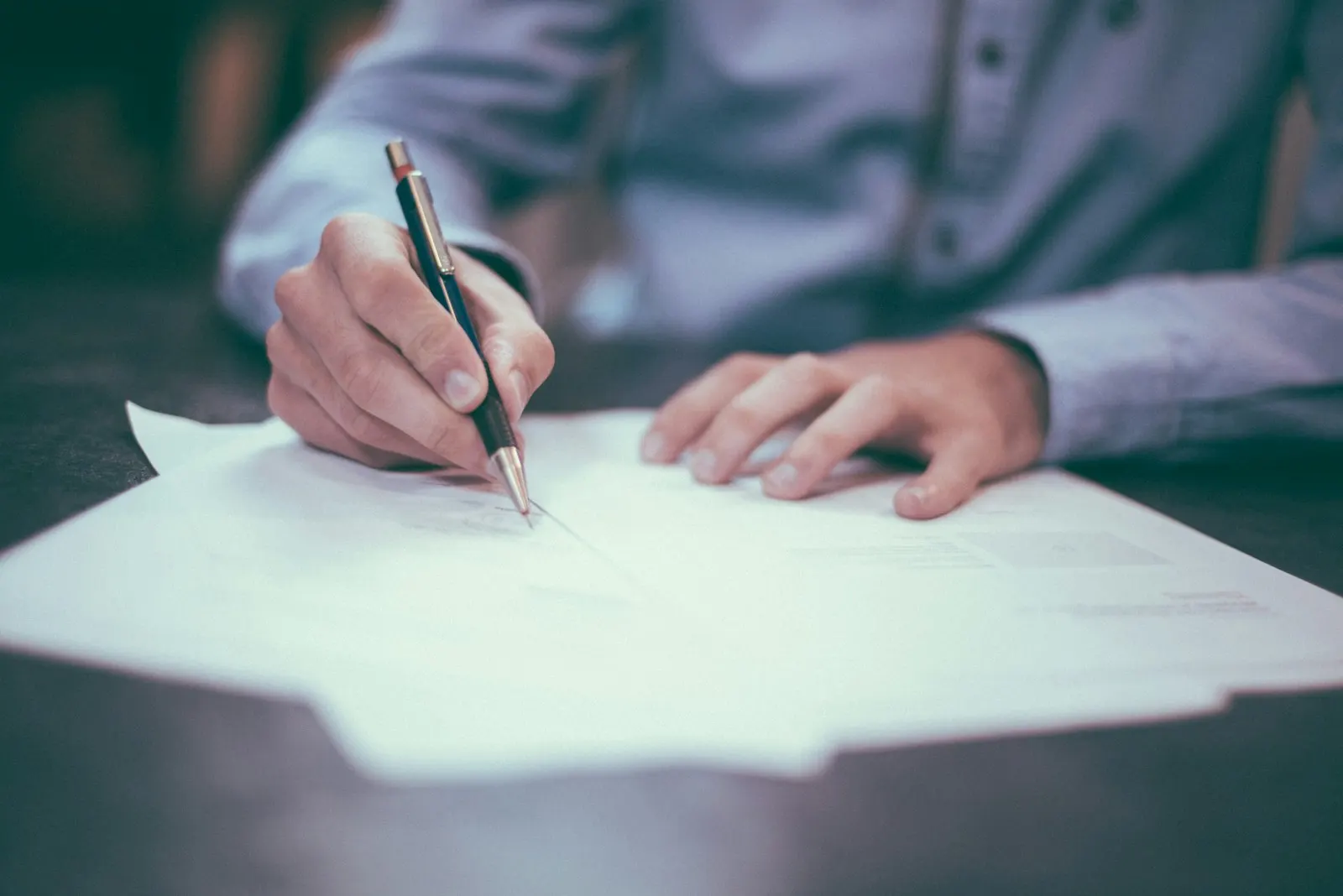 Person completing a document at a desk